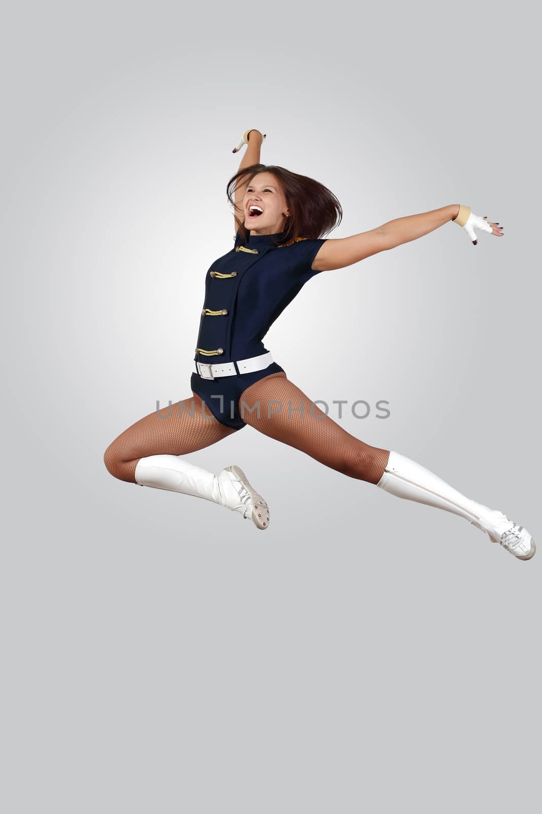 Young female dancer jumping against white background