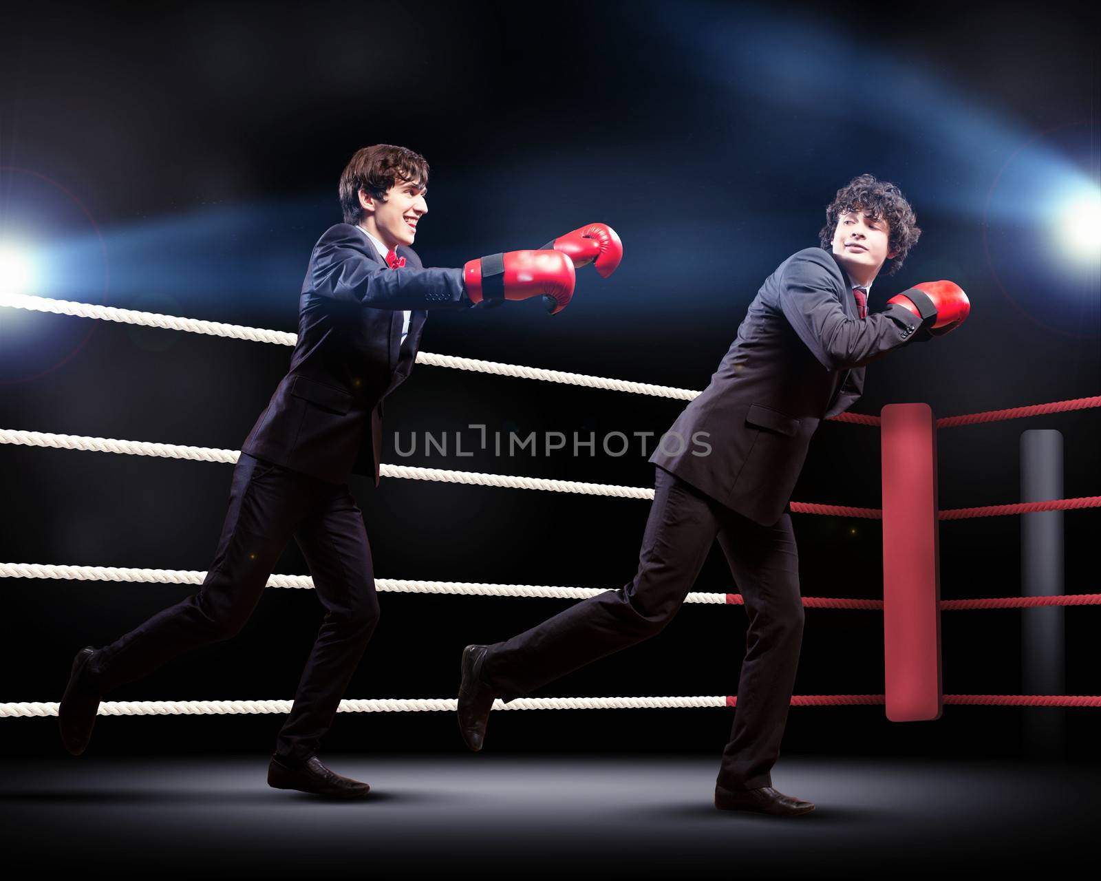 Two young businessman boxing againts dark background . conceptual collage