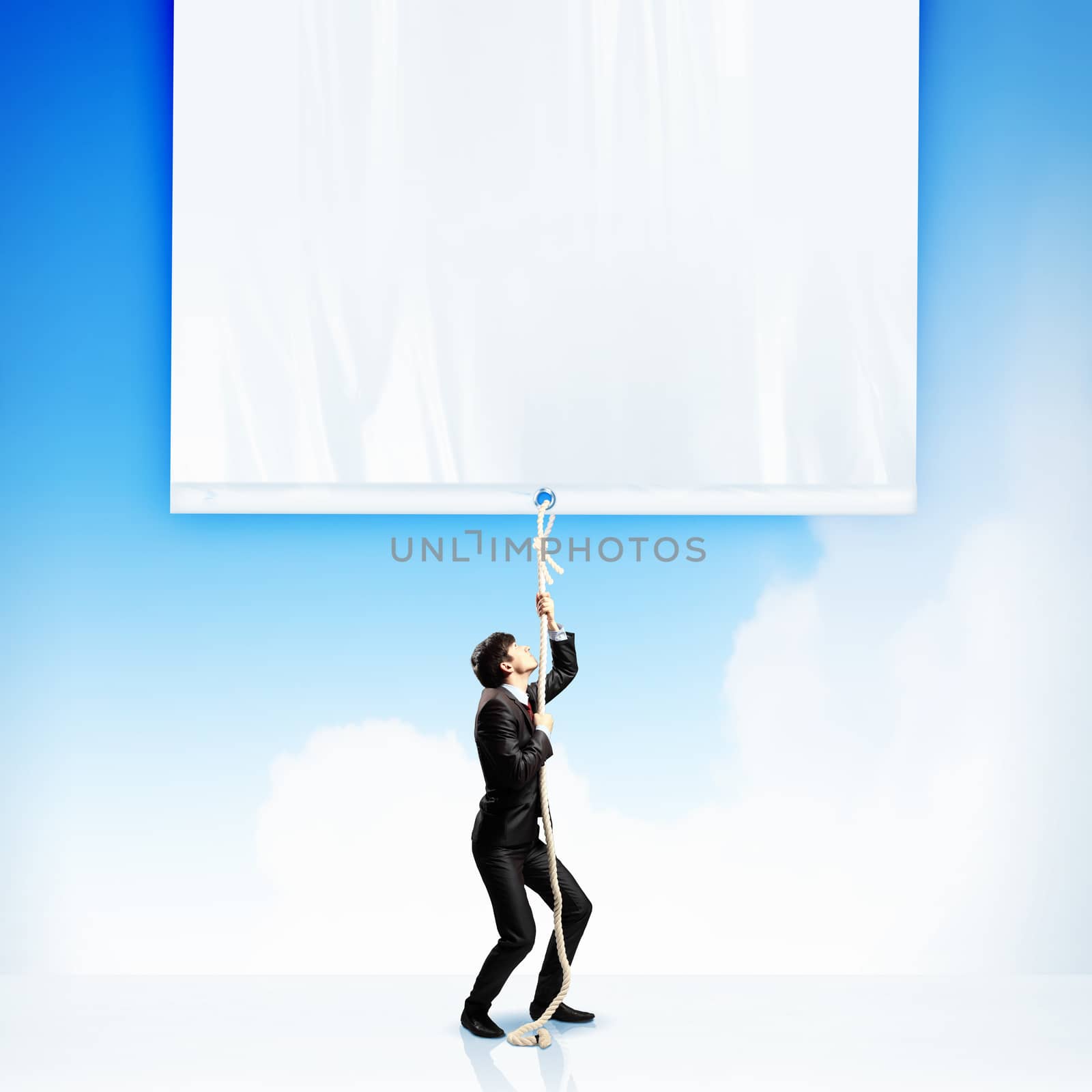 Image of young businessman pulling blank banner. Place for text