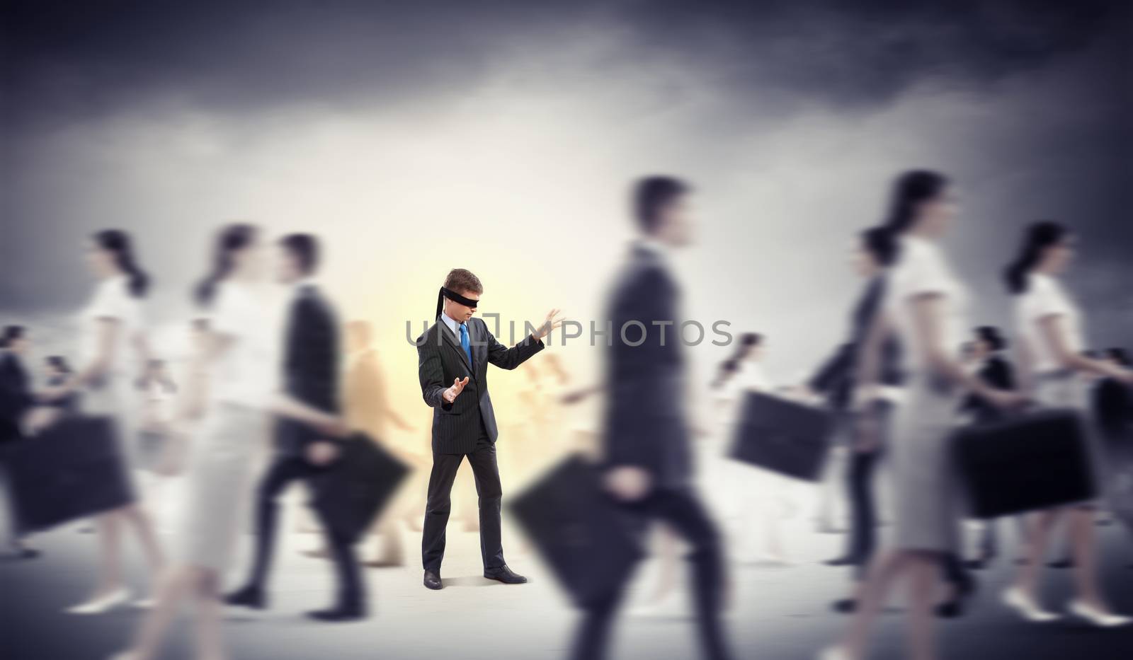 Image of businessman in blindfold walking among group of people