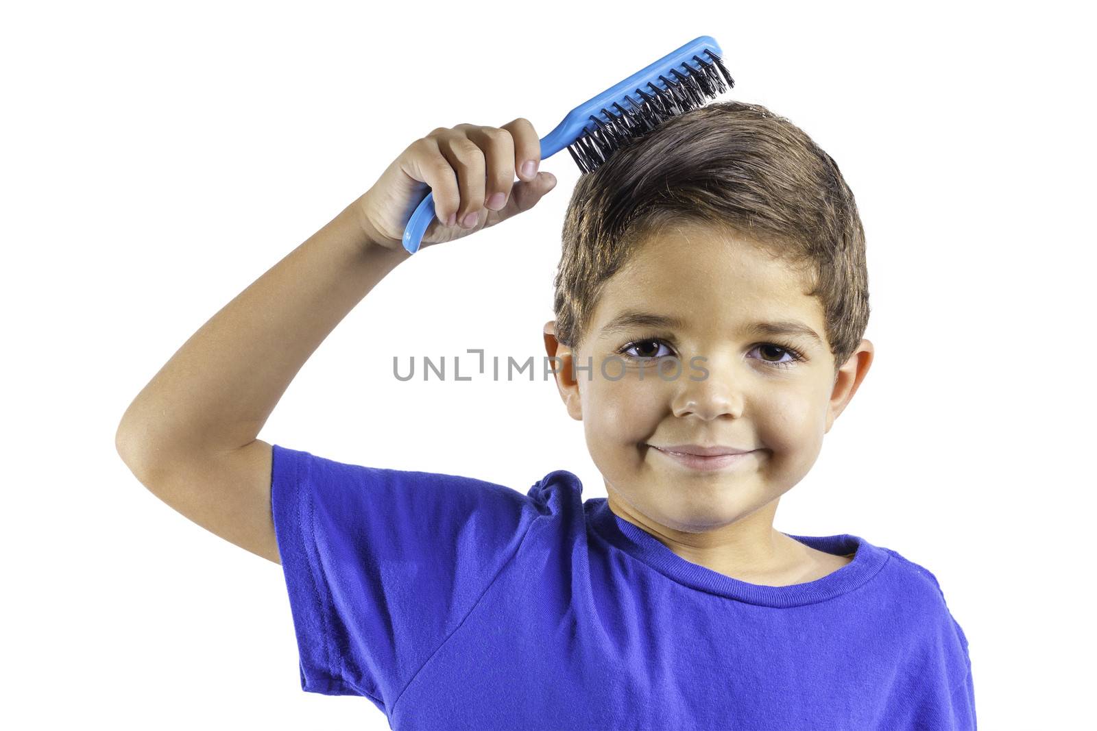 An young boy brushing his hair isolated on a white background.