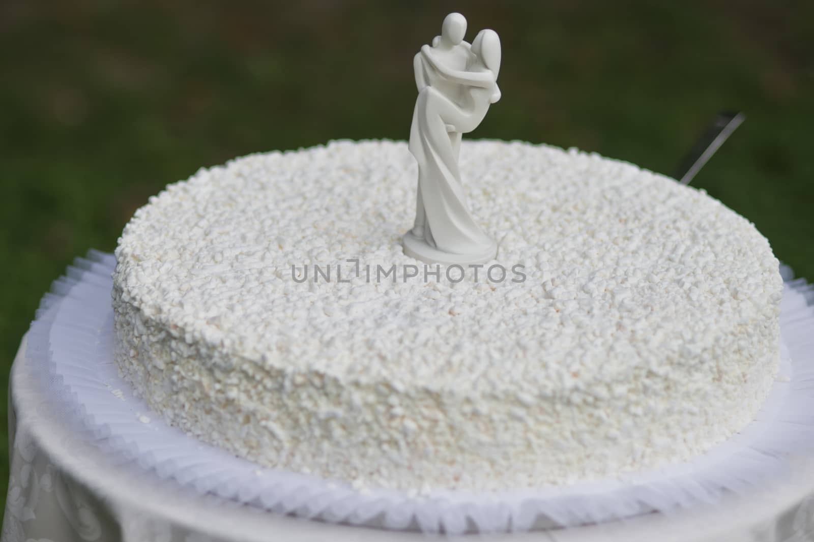 White wedding cake with white figures of bride and husband