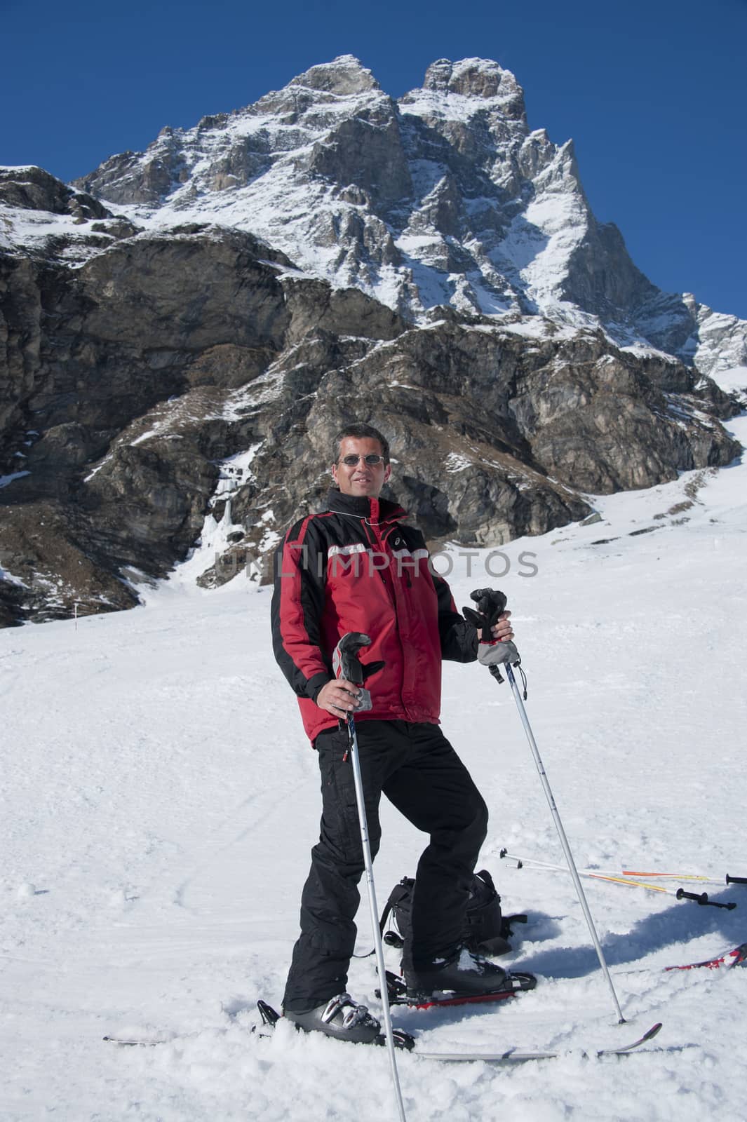 man staying on the ski, on a slope under the Matterhorn