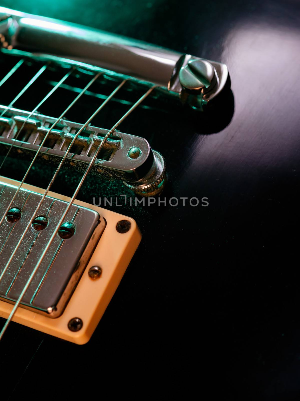 Macro abstract photo of the pickup, bridge and strings of an electric guitar. Shallow depth of field with focus across the middle.