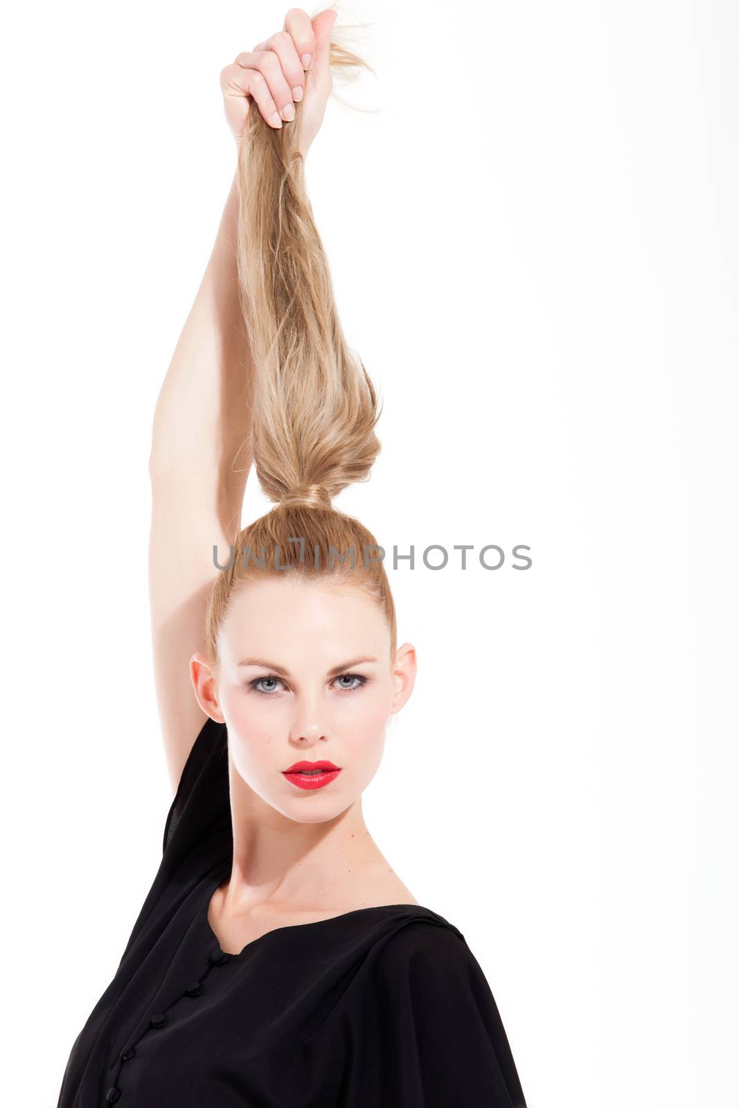 Beautifull young blond woman in the studio holding up her hair