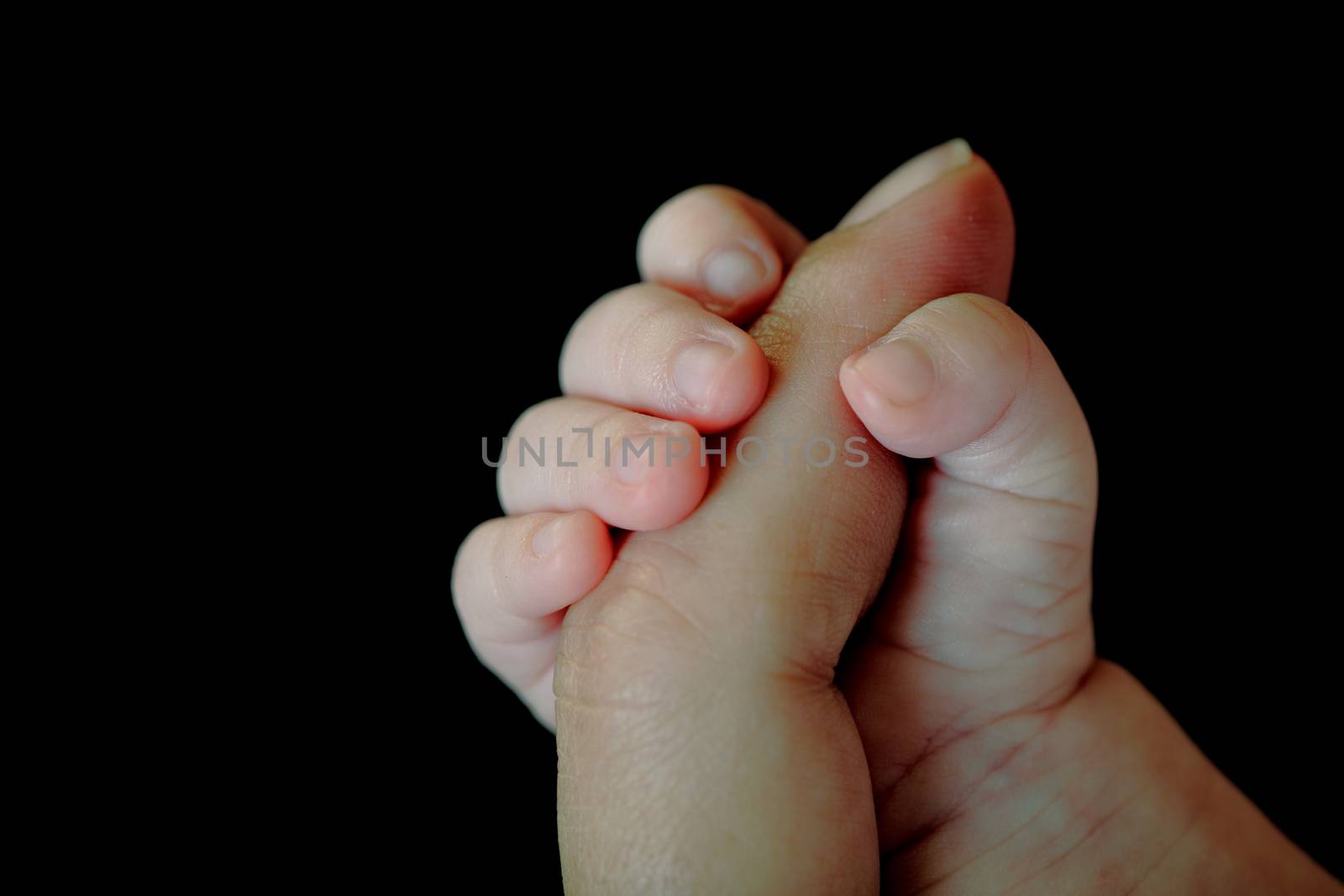 baby hand taking the finger of her mother