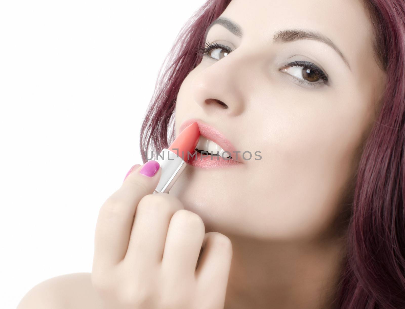 Close up of a young women applying lipstick