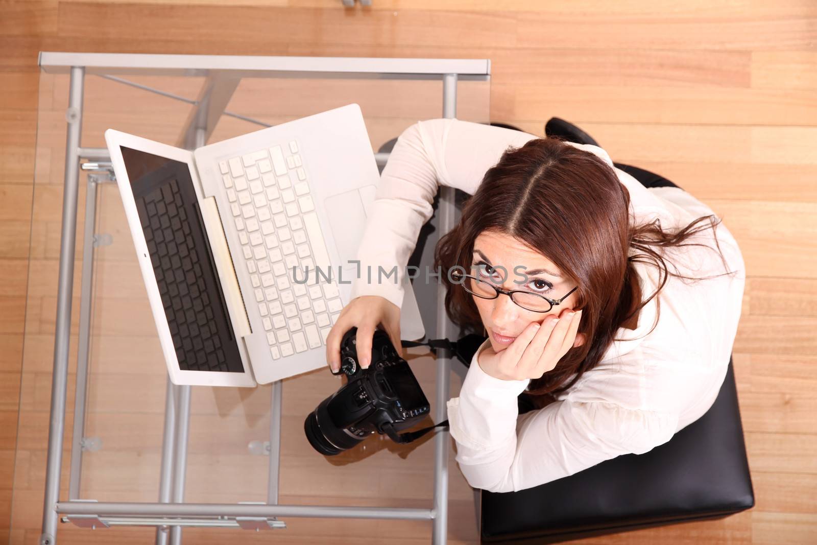 A young adult woman reviewing and downloading photos from a digital camera.