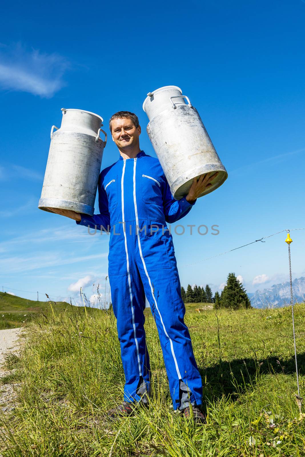 Herdsman standing in front of cattle in farm