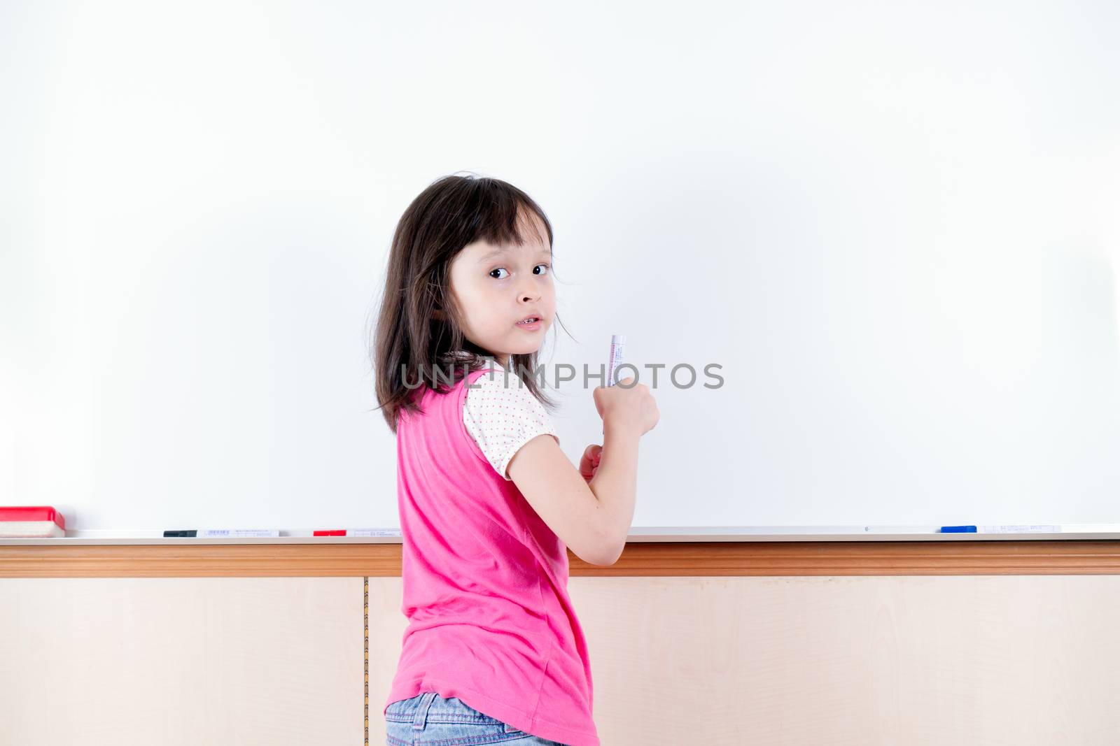Child at whiteboard looking back