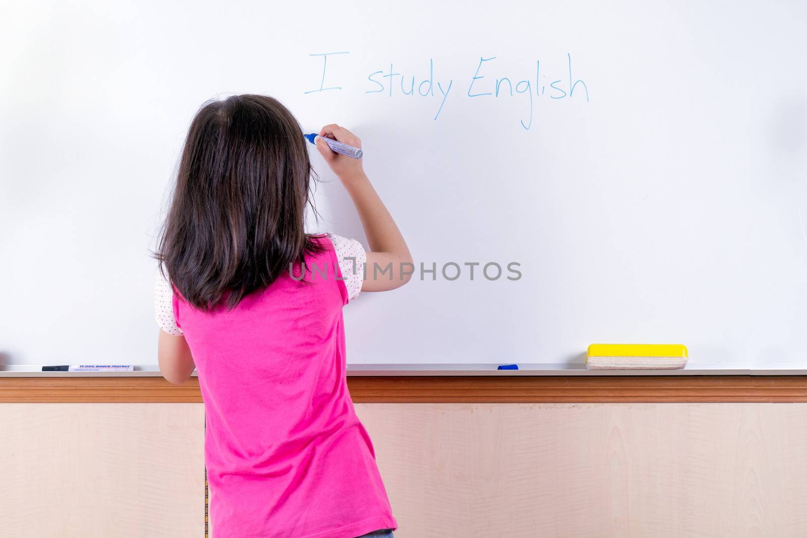 Child at whiteboard writing I study English