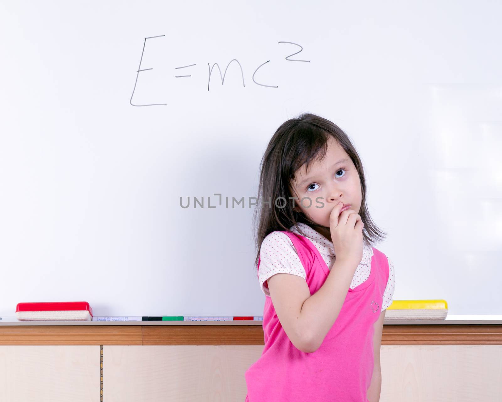 Child at whiteboard thinking about E=MC2