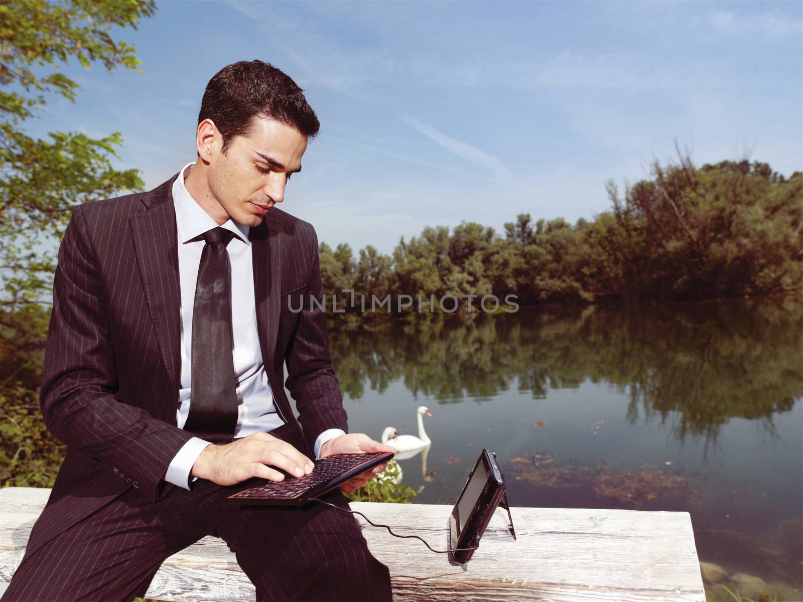 Beautiful young businessman using laptop outdoors 