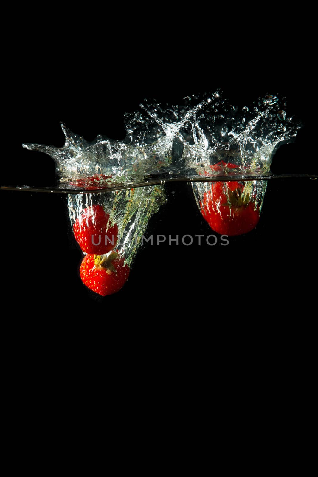 Colored red paprika in water splashes on black background