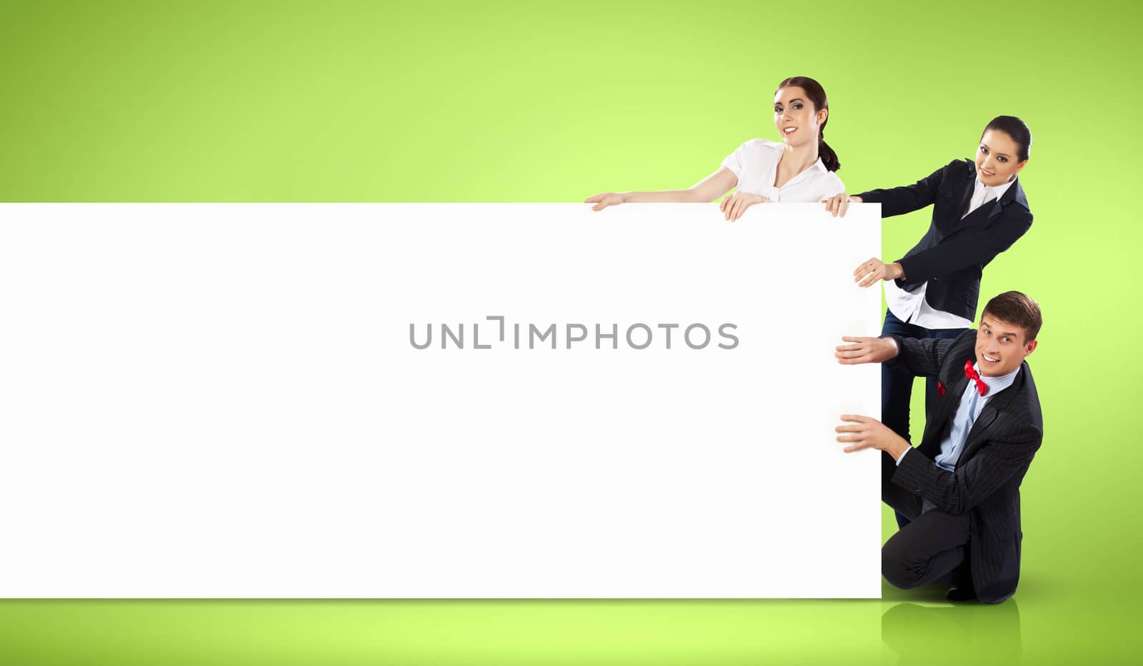 Image of three young people holding blank banner against green background. Place for text