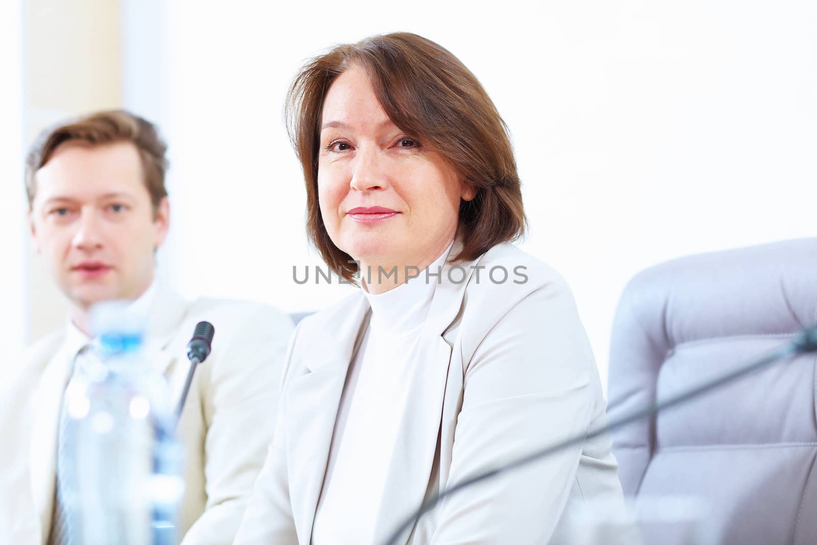 Image of two businesspeople sitting at table at conference