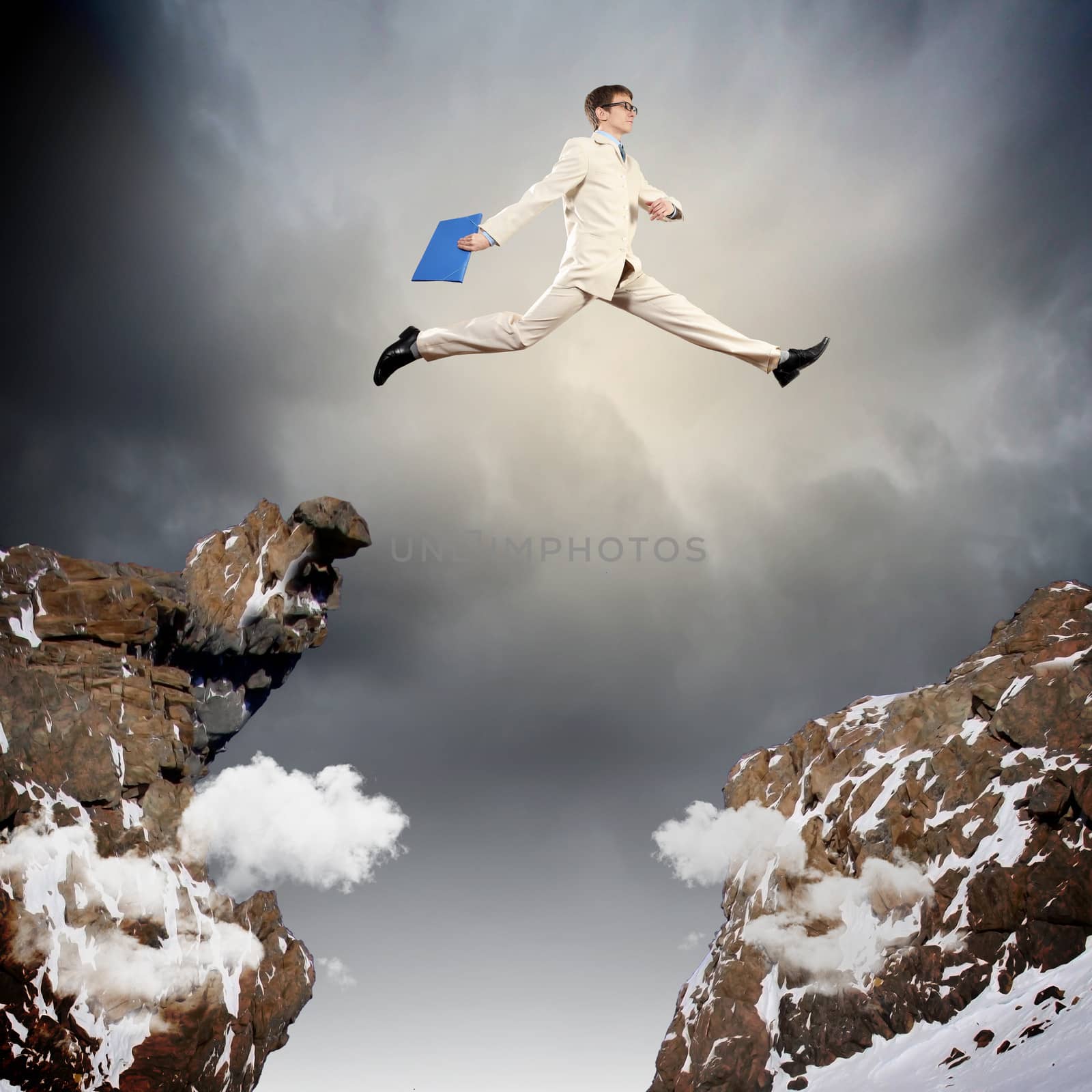 Image of young businessman jumping over gap