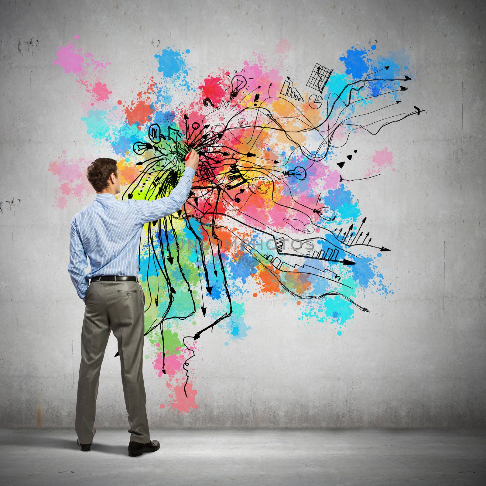 Back view of businessman drawing colorful business ideas on wall