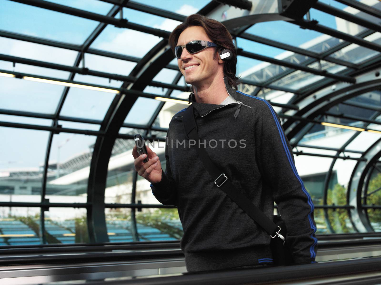 businessman walking down the airport and talking by mobile phone