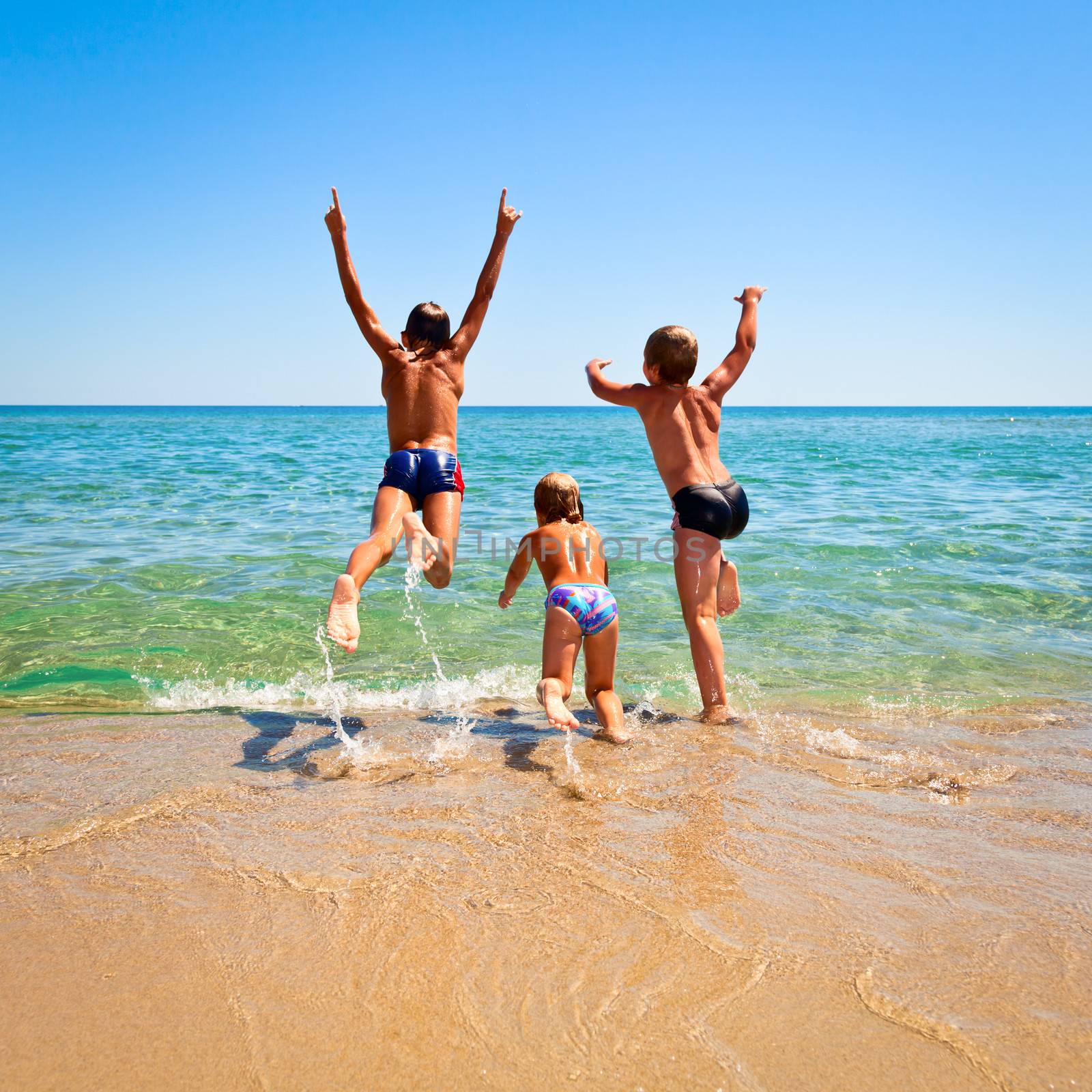 Three kids jumping to the sea