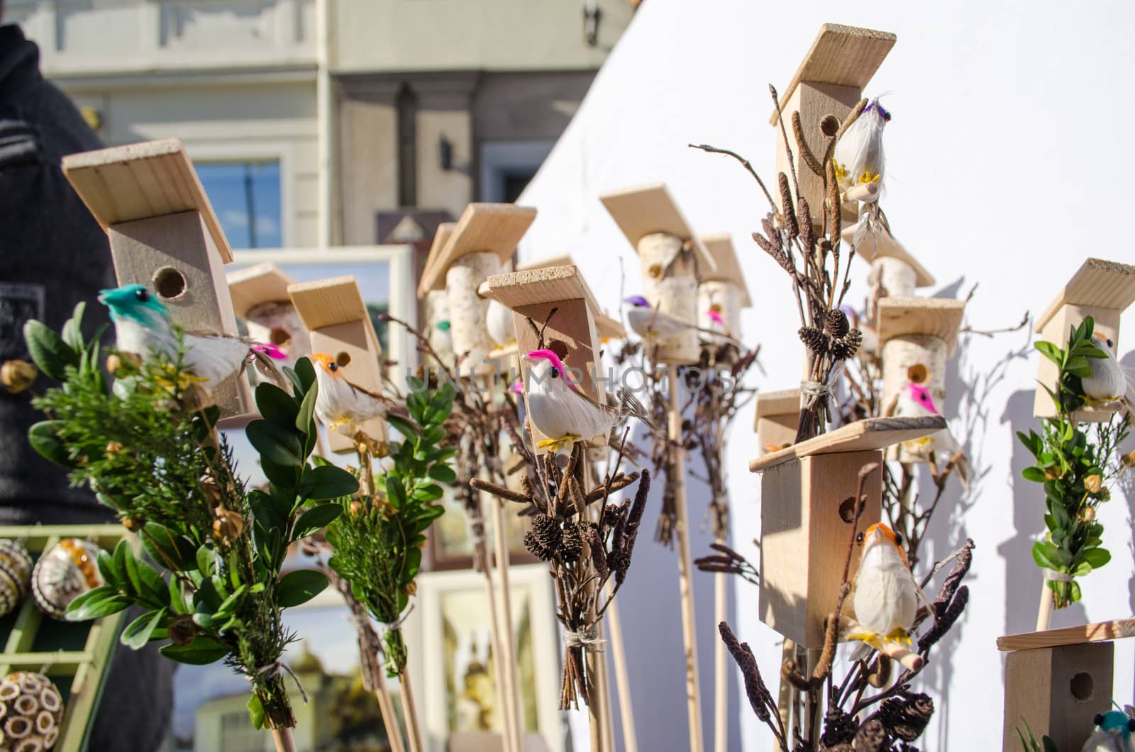 small decor wooden bird houses boxes and little colorful handmade bird shape figures sold in outdoor spring easter fair market.