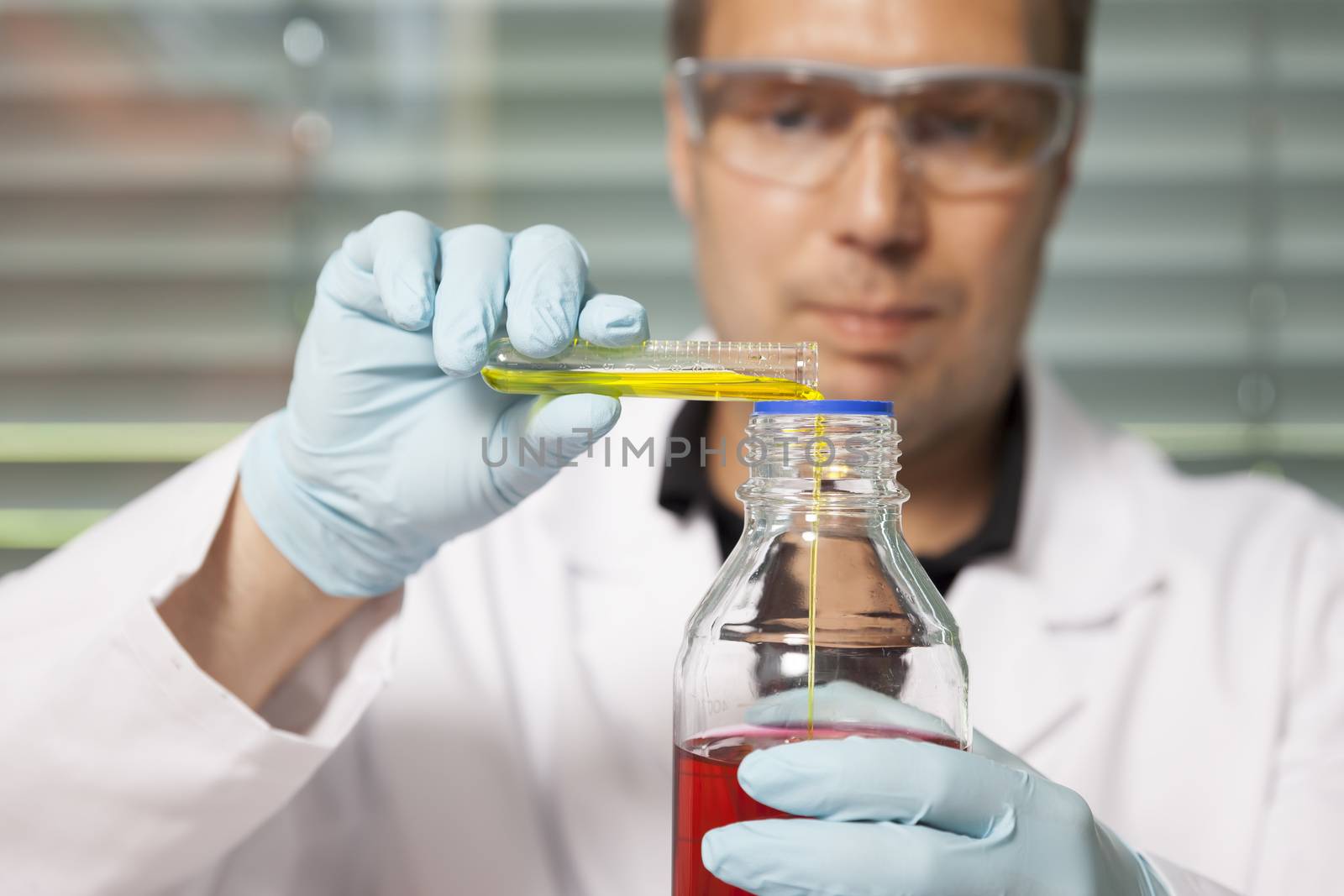 A man with red and yellow liquid in a laboratory