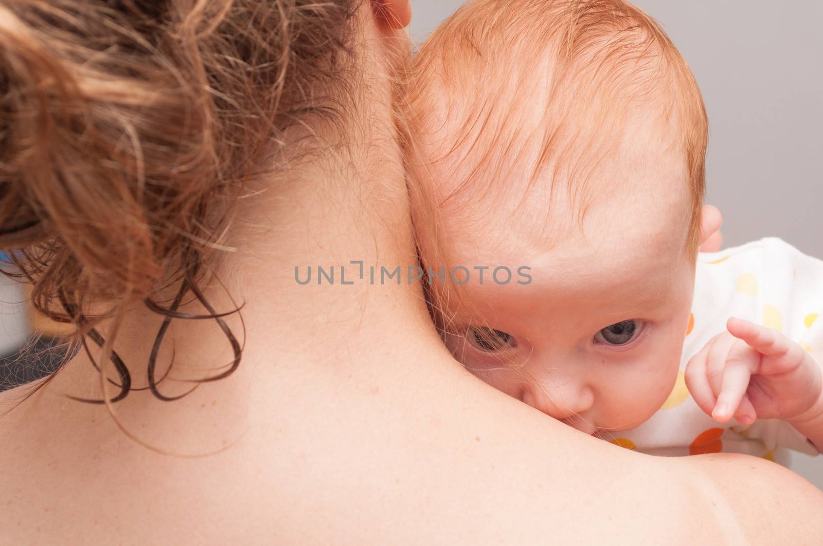 Mother from Behind Holding  Newborn Baby