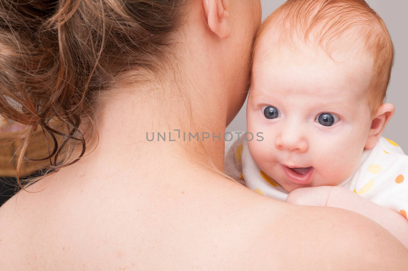 Mother from Behind Holding  Happy Newborn Baby