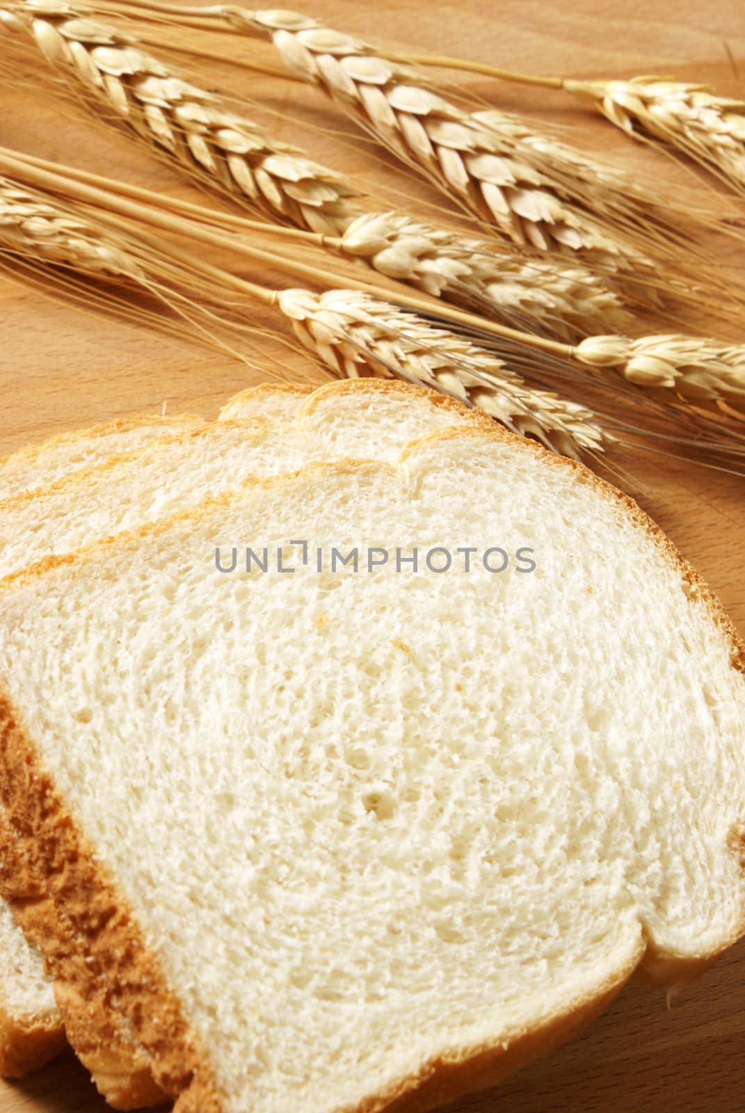 A closeup of some fresh baked bread that has been sliced on a wooden board.