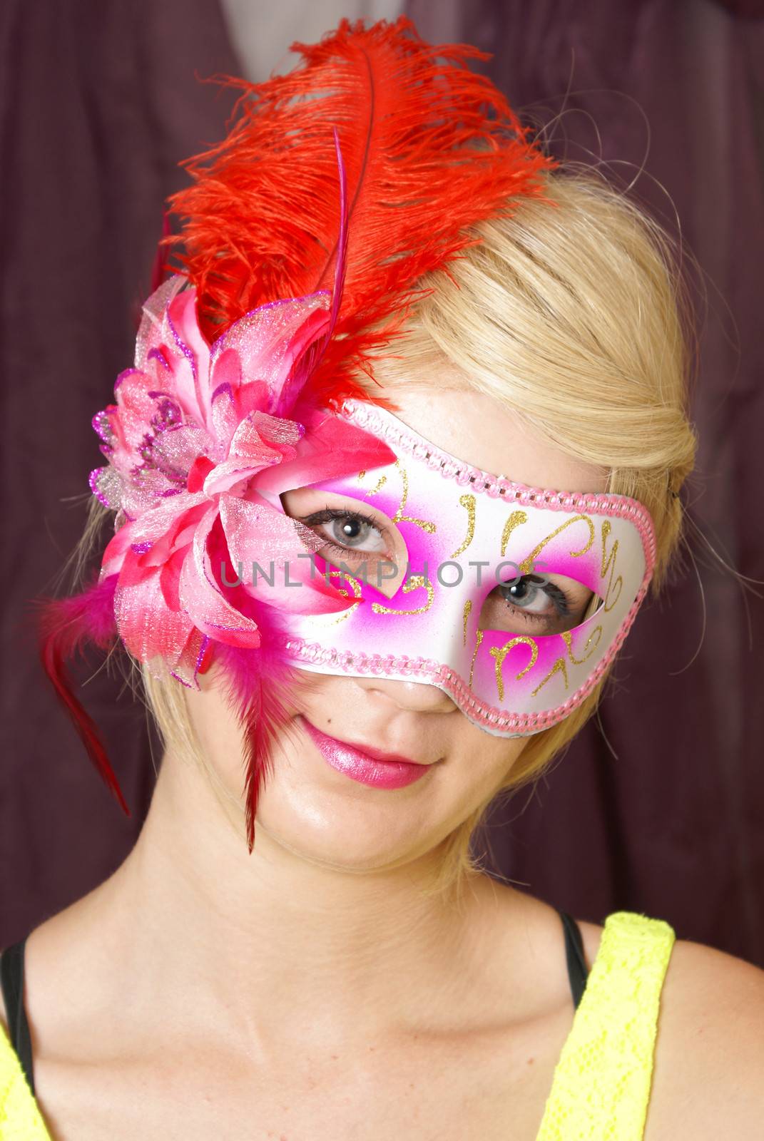 An attractive woman poses with her venetian mask.