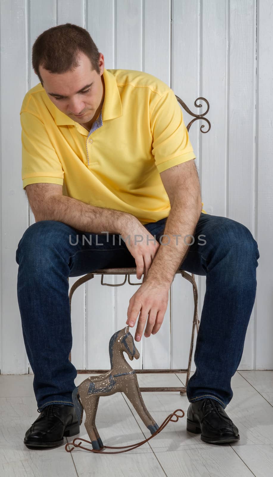 man sitting and looking at a child toy