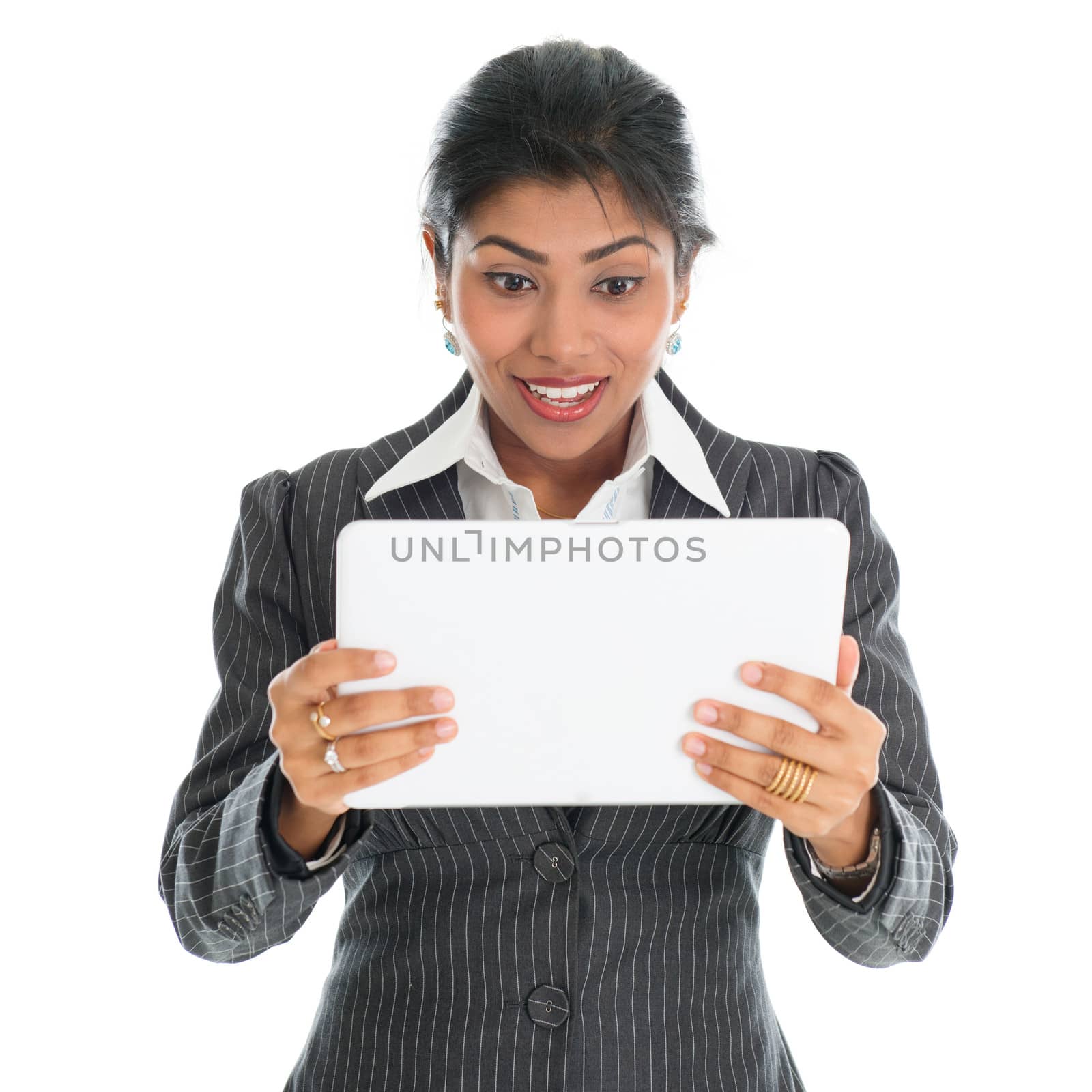 African American businesswoman looking at digital computer tablet with surprise face, isolated over white background. Mixed race Asian Indian and African American model.