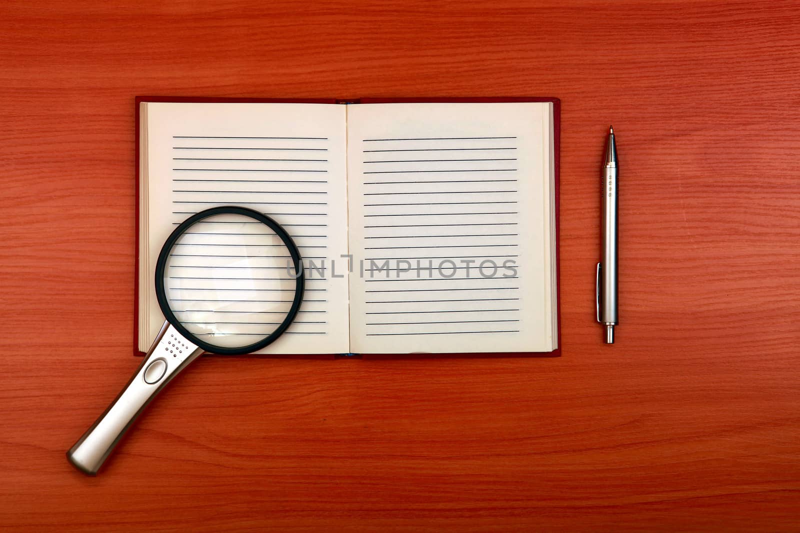 Writing Pad with Loupe and Pen on the Wooden Table