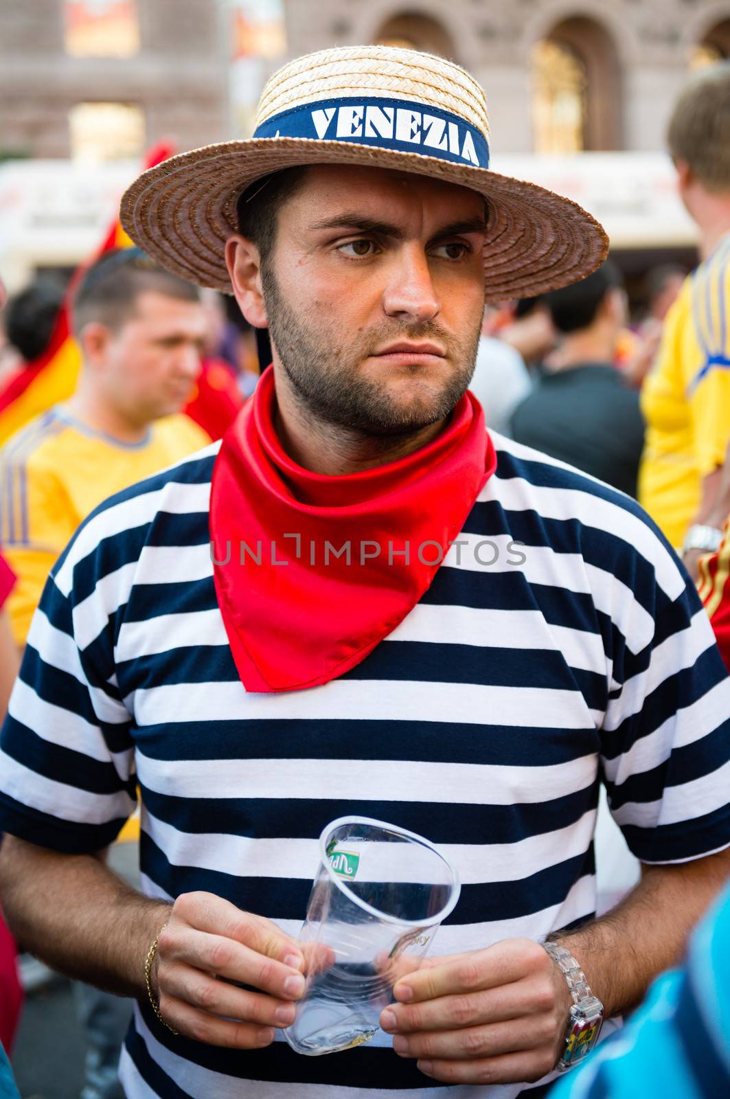 KIEV, UKRAINE - JUL 1: Sad Italian football fan with empty beer glass stand on the central fan zone before  EURO 2012 final match Spain vs. Italy on July 1, 2012 in Kiev, Ukraine