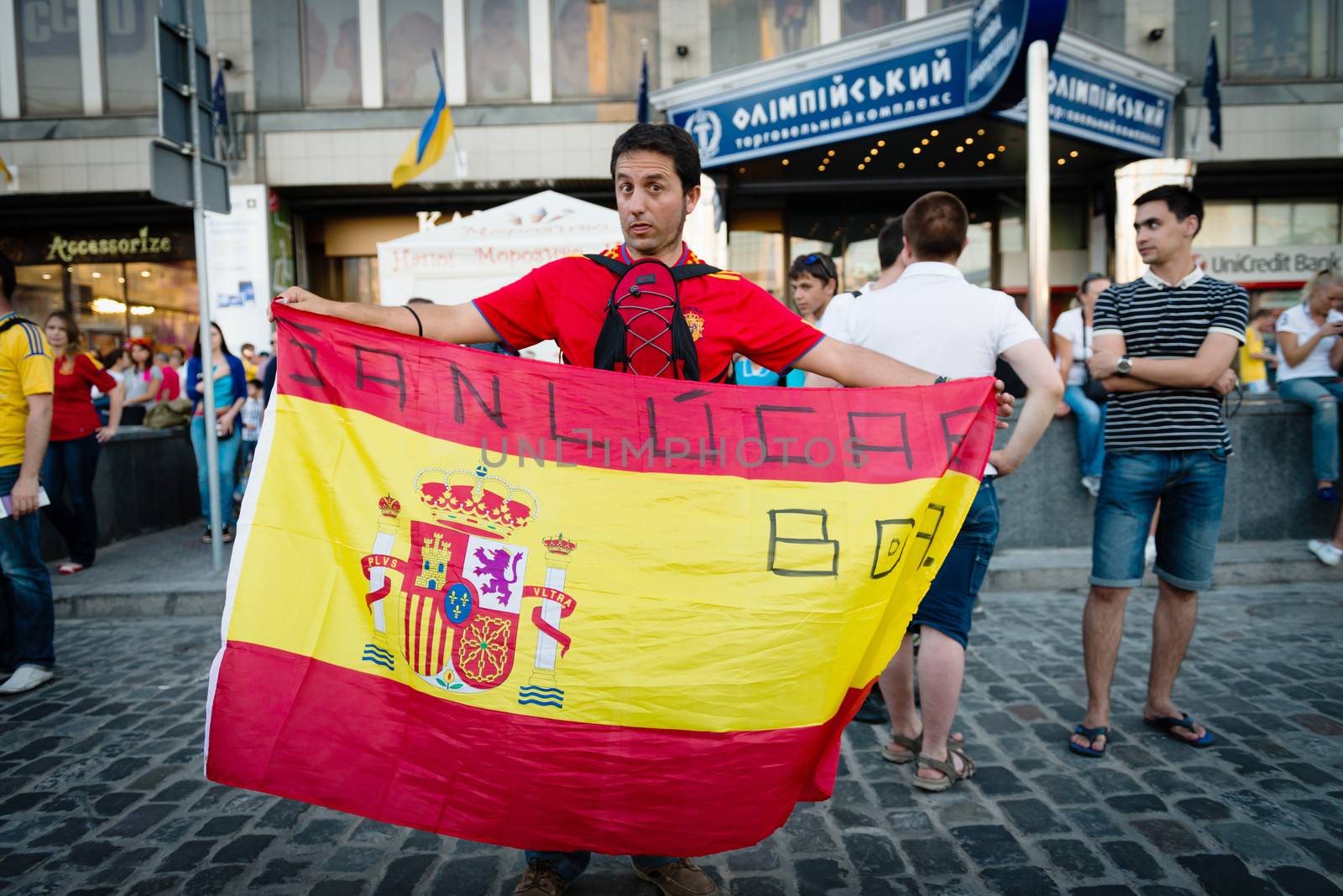 KIEV, UKRAINE - JUL 1: Spanish football fan with the flag goes to EURO 2012 final match Spain vs. Italy on July 1, 2012 in Kiev, Ukraine