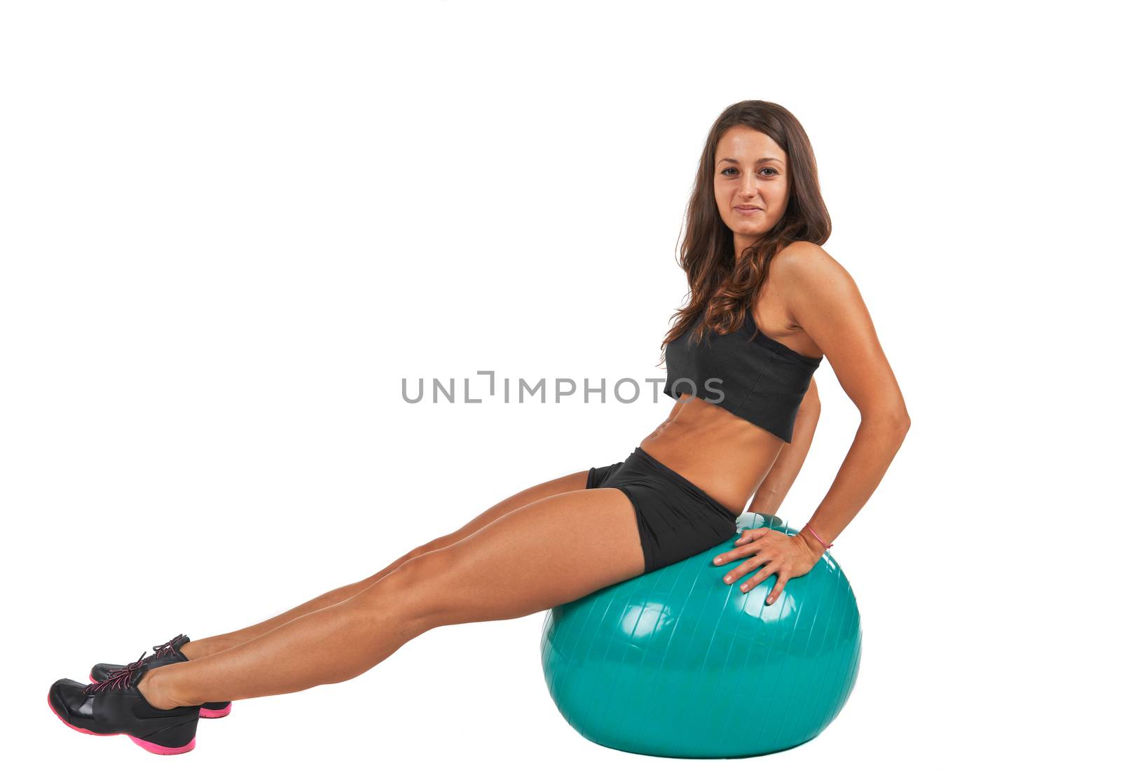Young woman in the studio with fitness ball against white background