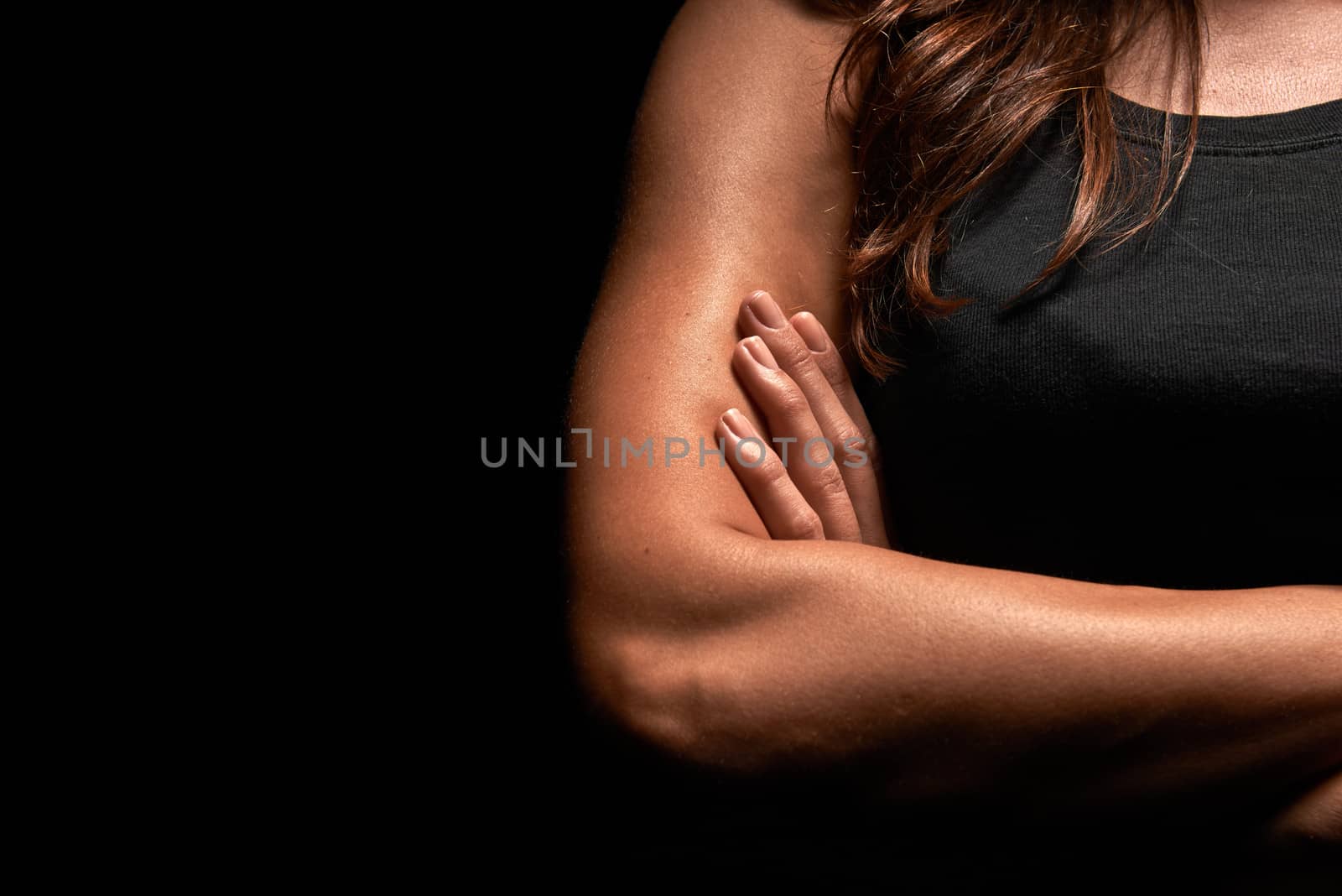 Upper body of a muscular woman in a studio