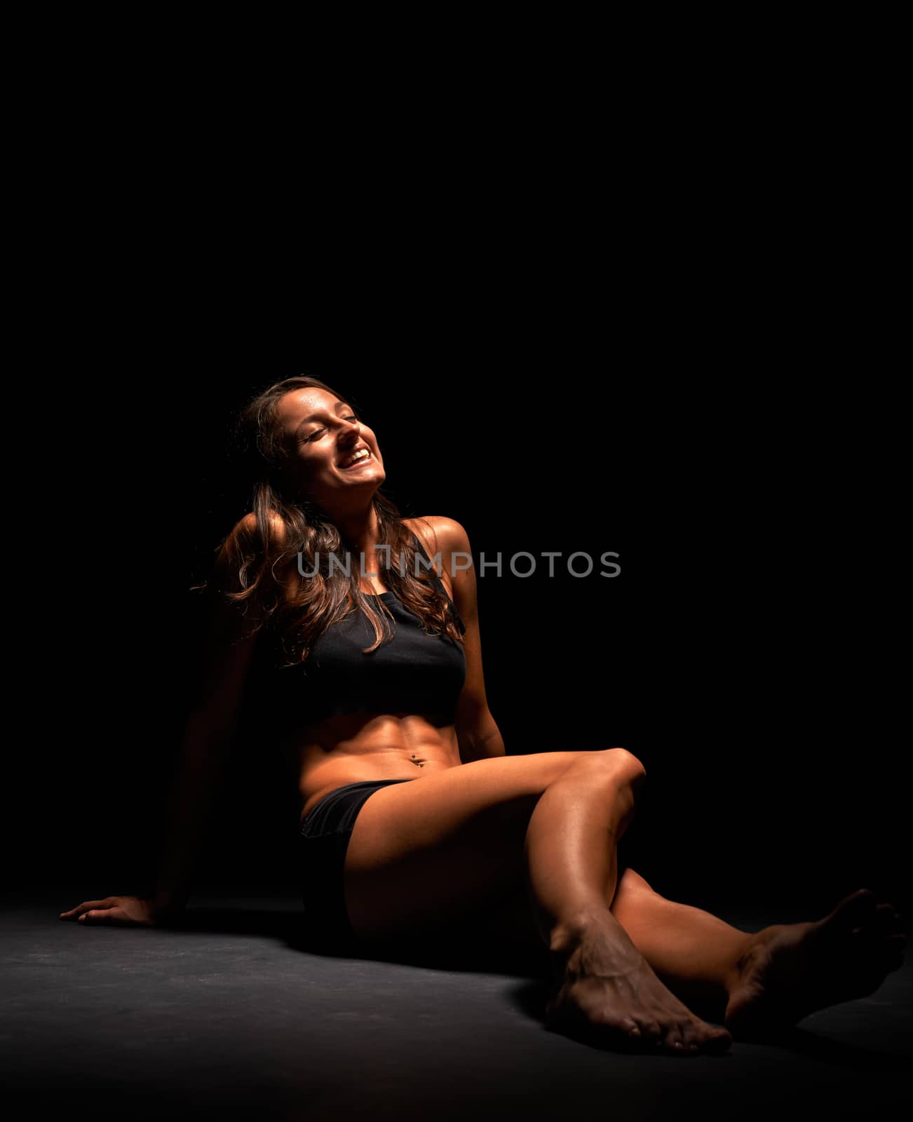 Young muscular woman under bright light by svedoliver