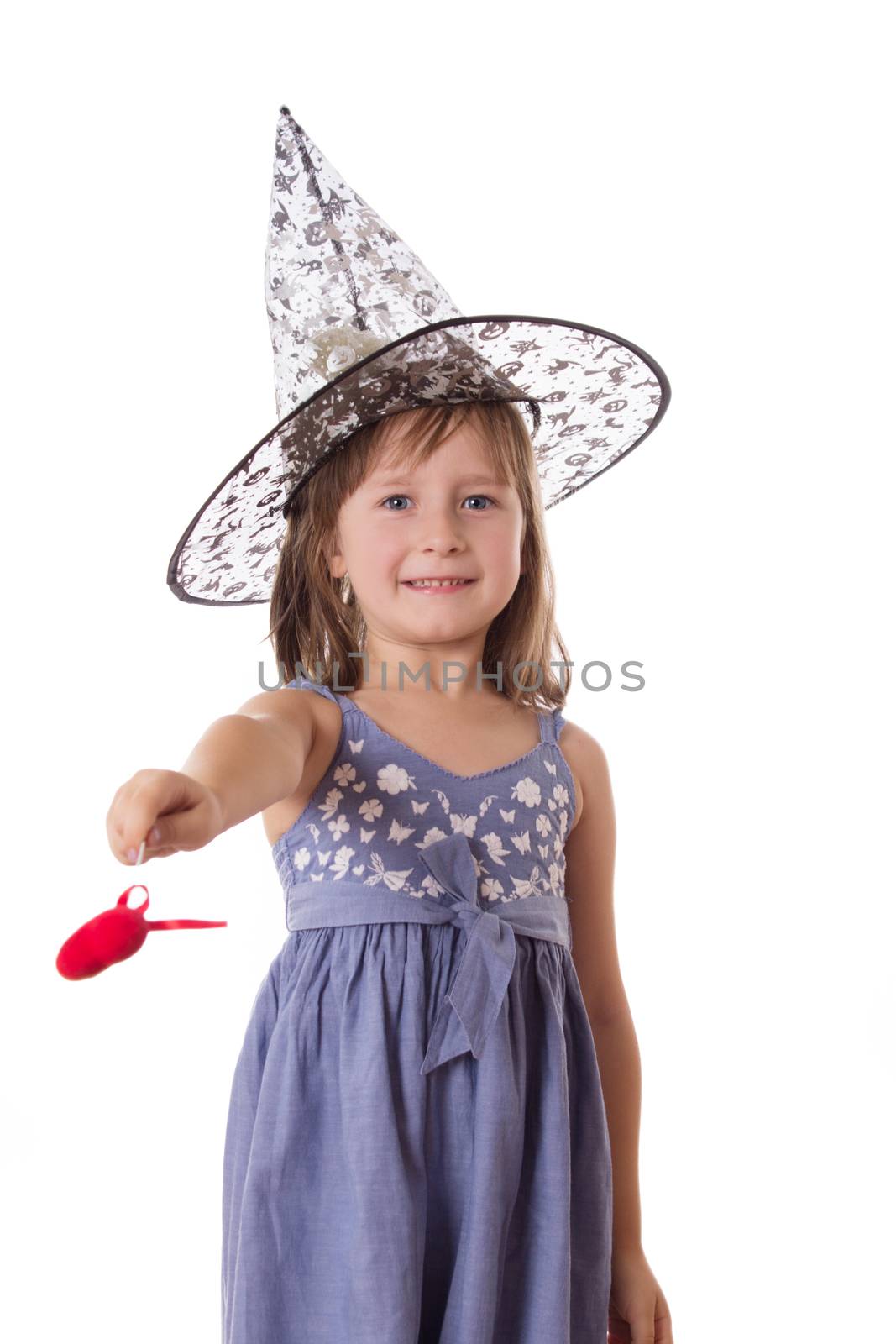 Adorable girl making magic with wand isolated on white