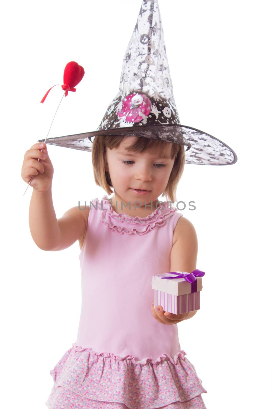 Adorable girl making magic with wand isolated on white