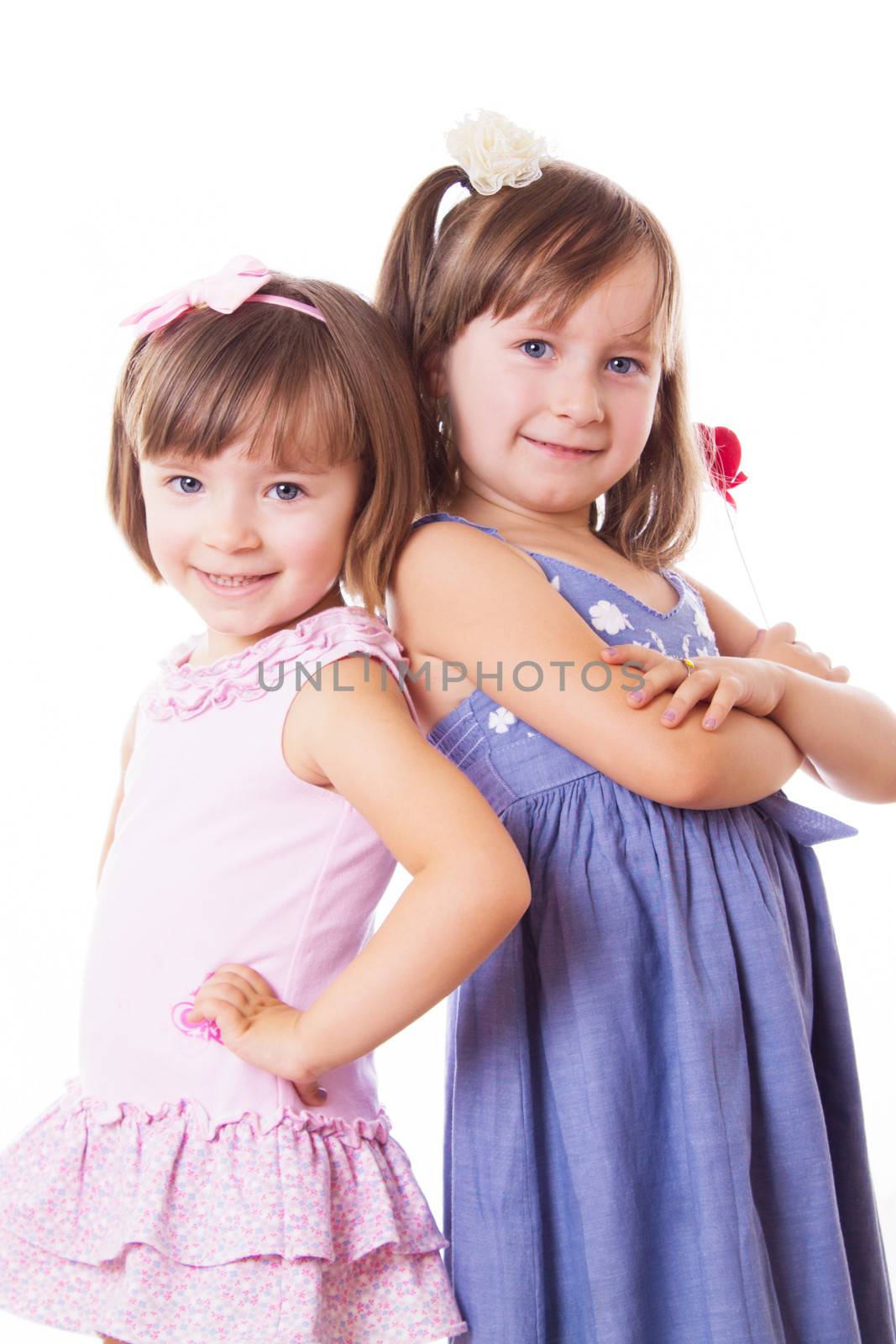 Two smiling sisters standing with their back isolated on white