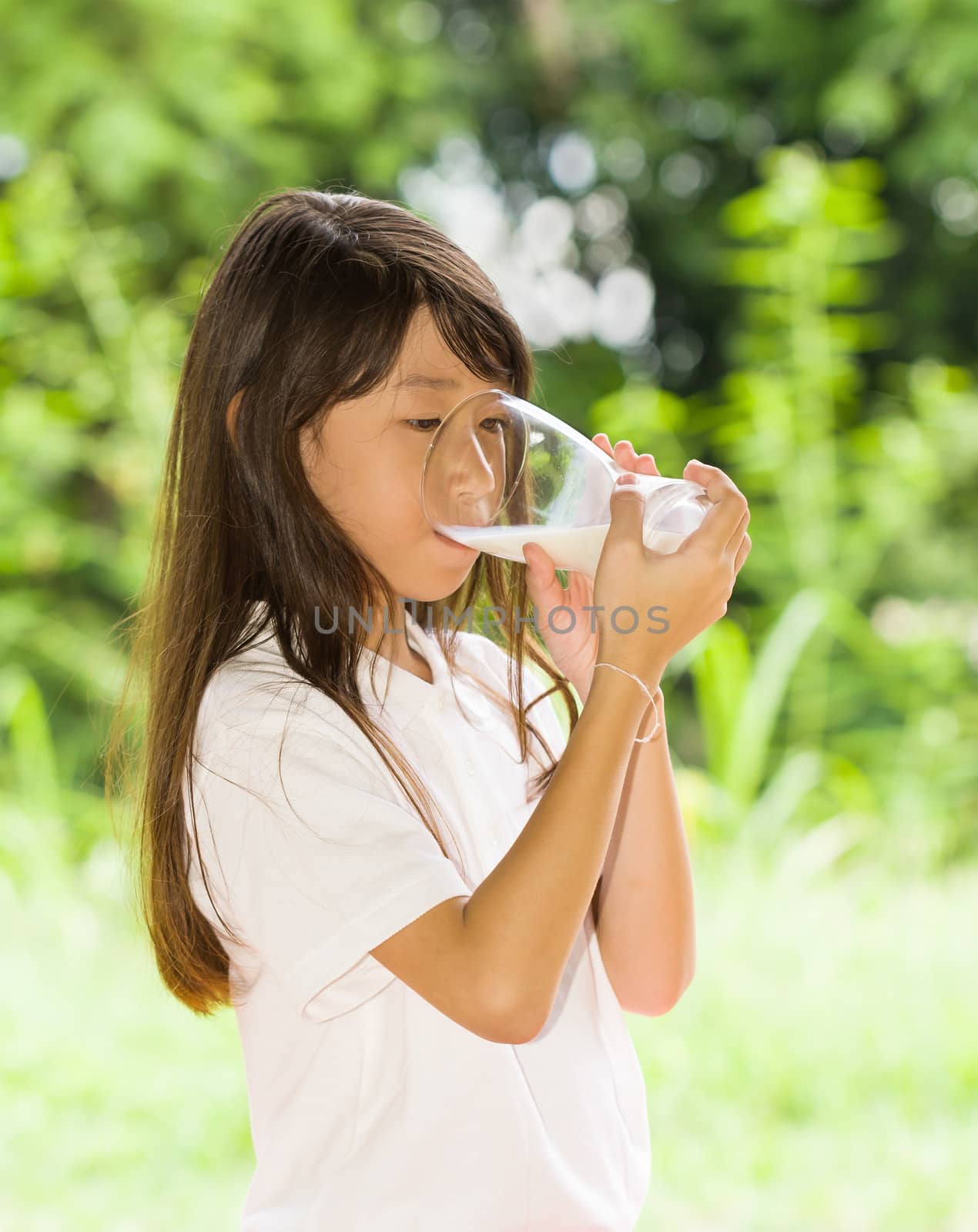 Asian girl drinking milk in the park