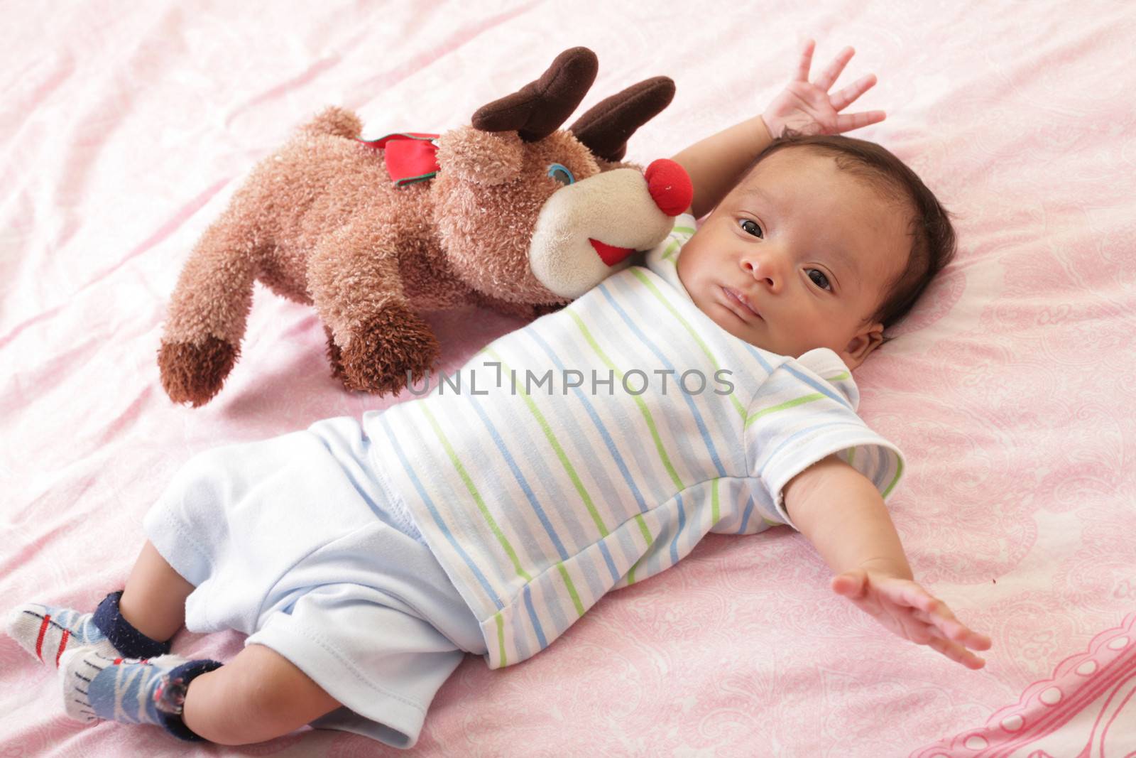 hispanic baby with teddy bear laying on bed by dacasdo