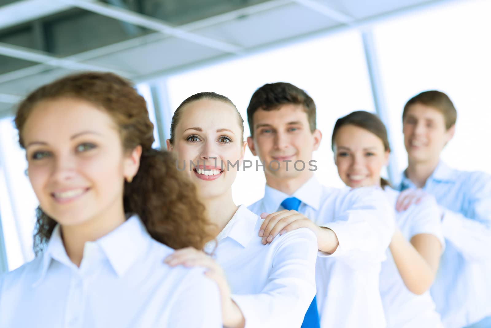 portrait of a young business woman standing in line with colleagues, concept of teamwork