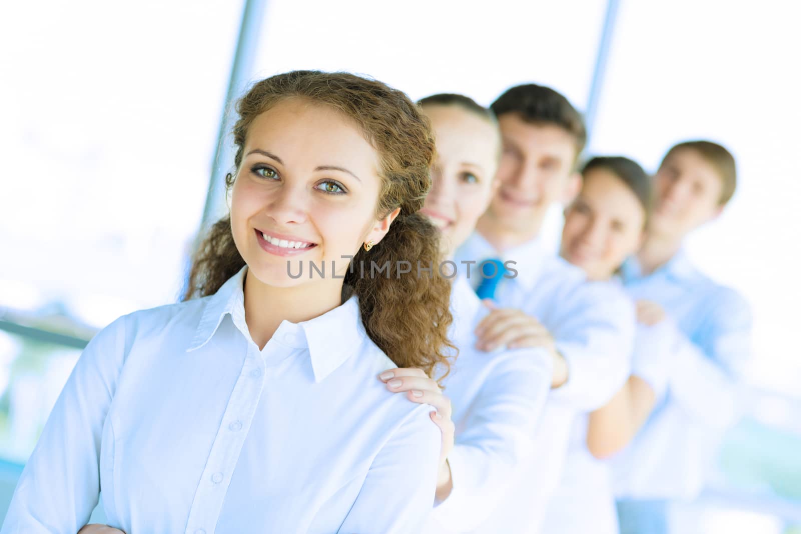 portrait of a young business woman standing in line with colleagues, concept of teamwork