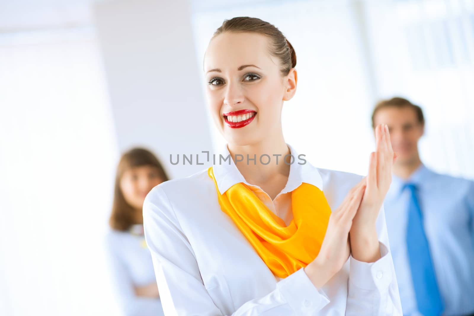 Portrait of a young successful business woman standing against colleagues