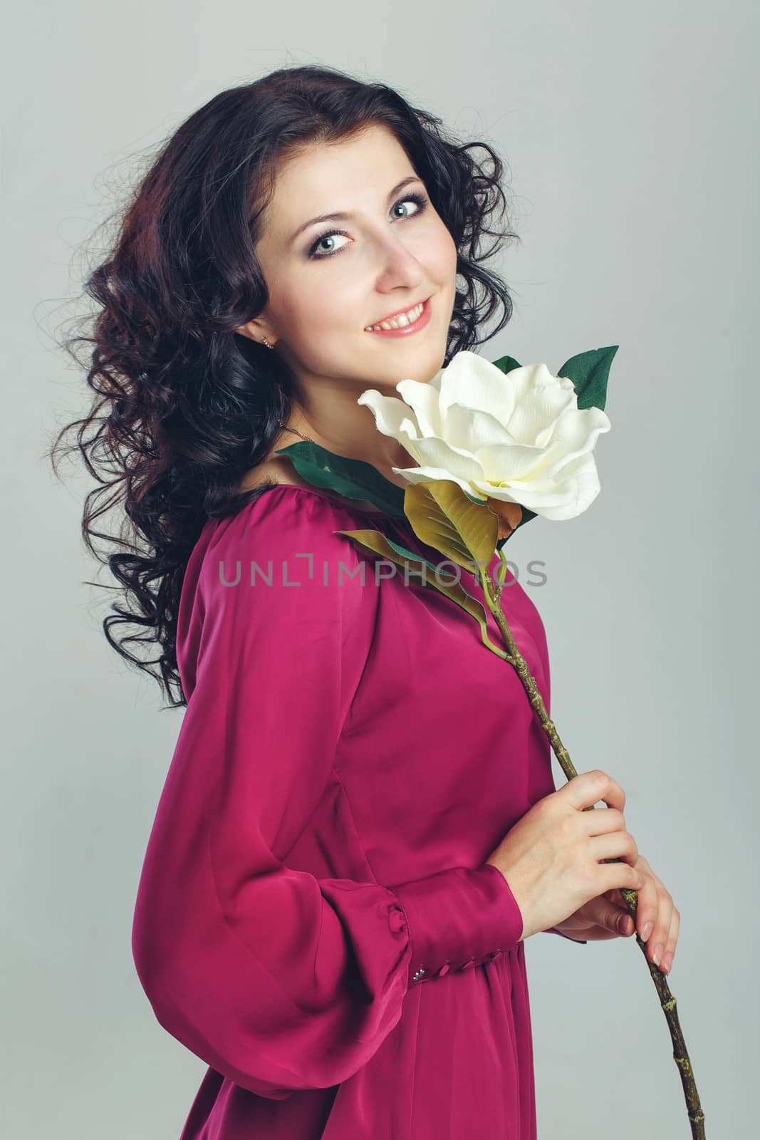 Girl in a dress holding a beauty flower. Photographed in the studio