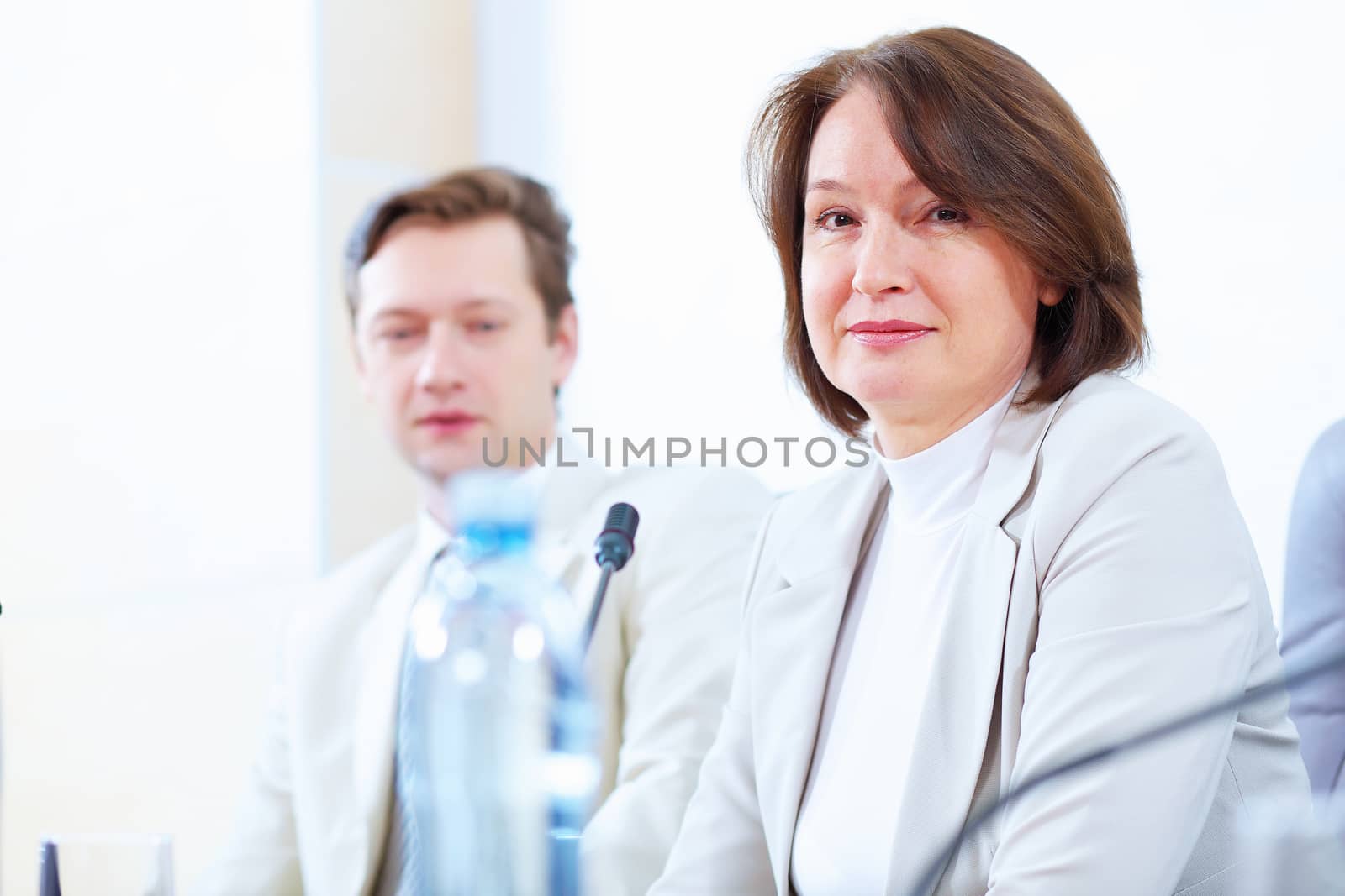 Image of two businesspeople sitting at table at conference