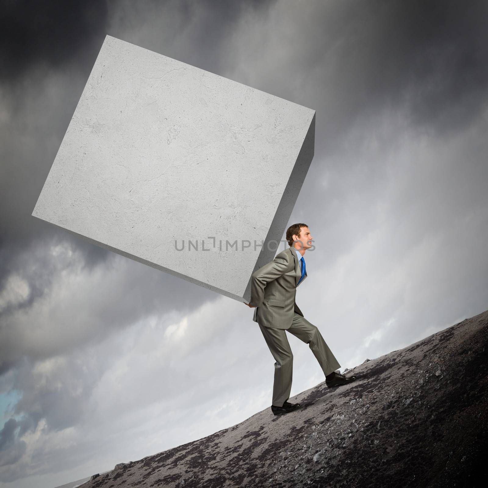 Image of businessman carrying big white cube on his back