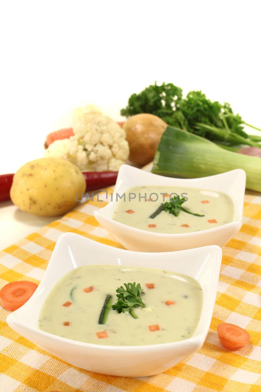 fresh vegetable soup with carrots and parsley on a light background